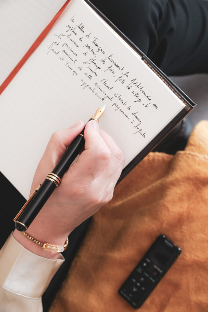 Mains d’une praticienne qui écrit dans un carnet, photo de marque