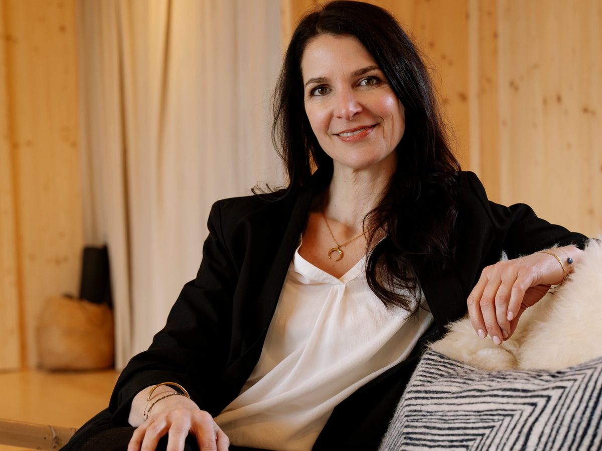 Sandrine souriante, assise sur un canapé