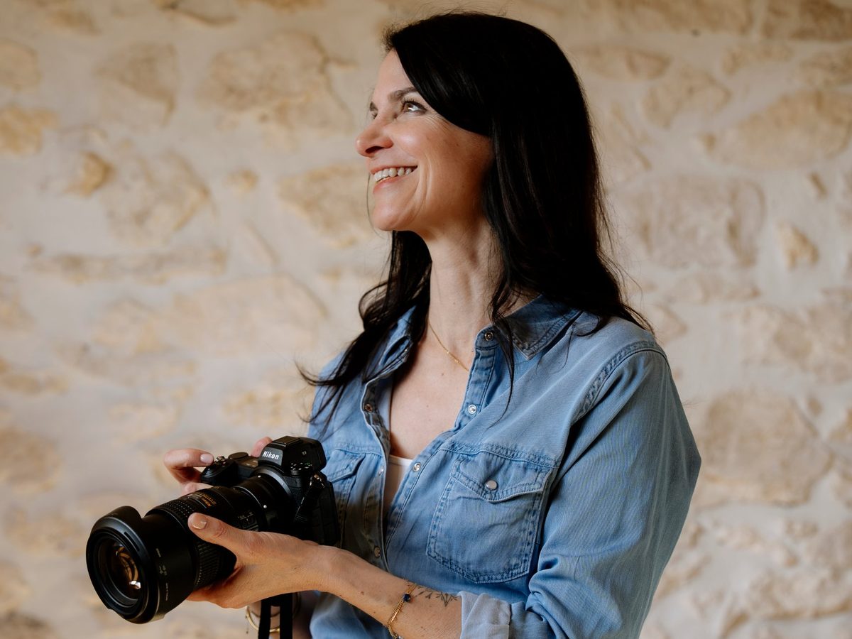 Sandrine souriante, appareil photo en main